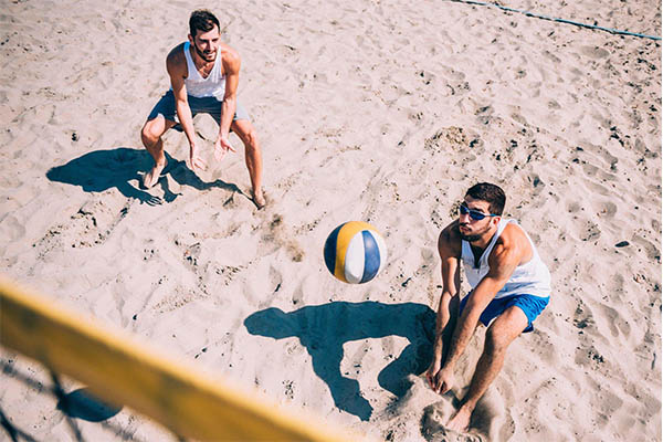 Dois homens praticando vôlei de praia